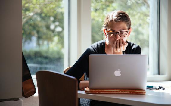 Student reading on her laptop.